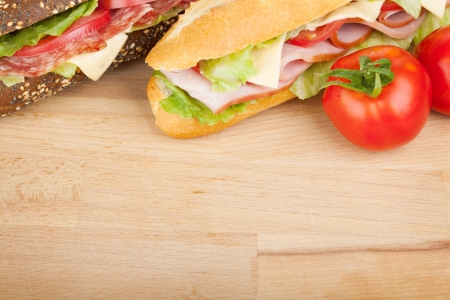 Fresh sandwiches with meat and vegetables and tomatoes. Closeup on wood tableの写真素材