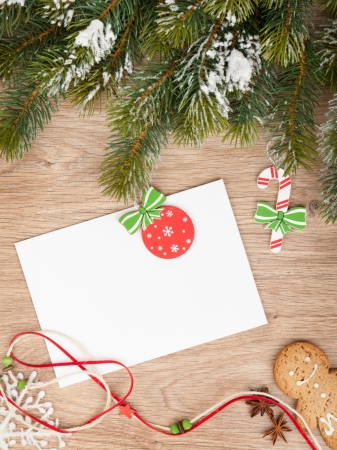 Christmas fir tree, gingerbread cookies and card for copy space on wooden tableの写真素材