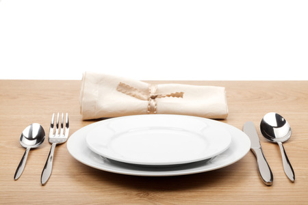 Empty plate and silverware set on wooden tableの写真素材