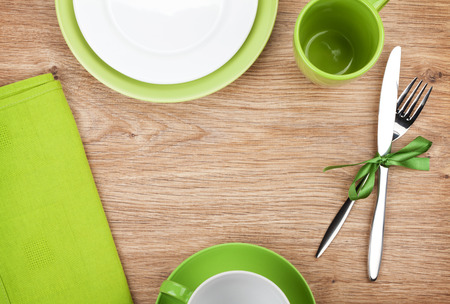 Kitchen utensils, plates, silverware over wooden table with copyspaceの写真素材