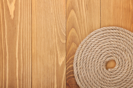 Roll of ship rope on wooden texture background