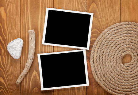 Blank photo frames with ship rope over wooden backgroundの写真素材