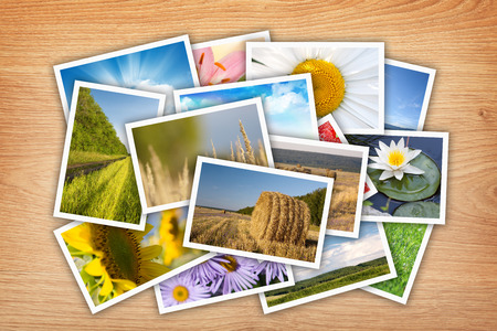 Stack of printed pictures collage on wooden table