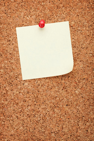 Blank postit note on cork wood notice board with copy spaceの写真素材