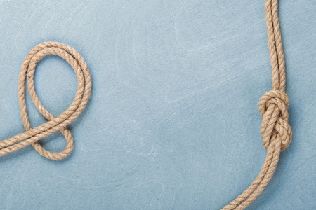Ship rope knot on blue wooden texture background