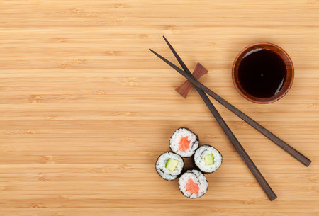 Sushi set, chopsticks and soy sauce over bamboo table with copy spaceの写真素材