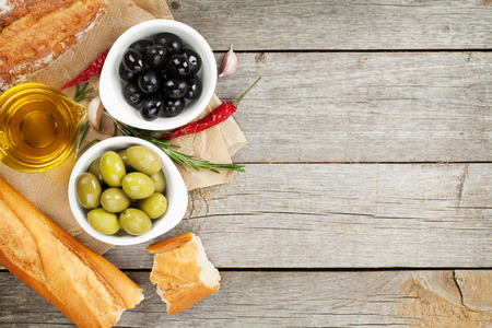Italian food appetizer of olives, bread and spices on wooden table background with copy spaceの写真素材