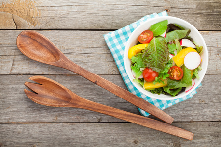 Fresh healthy salad on wooden table and kitchen utensil. の写真素材