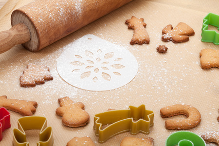 Rolling pin and gingerbread cookies on cooking paperの写真素材
