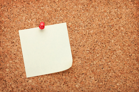 Blank postit note on cork wood notice board with copy spaceの写真素材