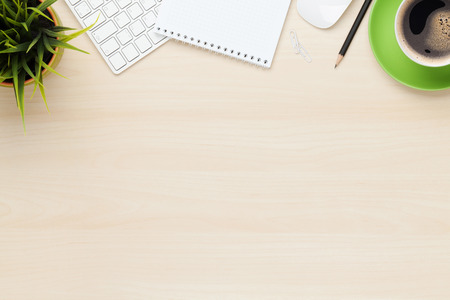 Office table with notepad, computer and coffee cup. View from above with copy space