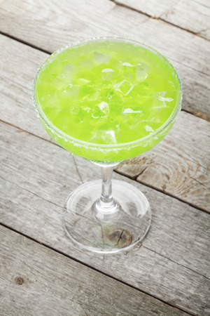 Classic margarita cocktail with salty rim on wooden tableの写真素材