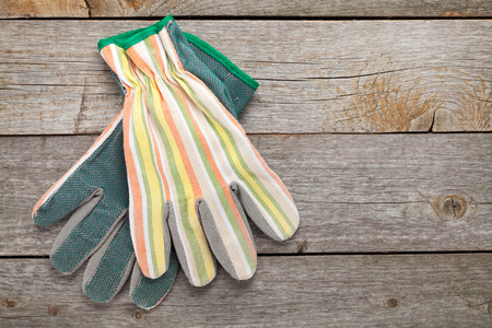 Gardening gloves on wooden table background with copy space