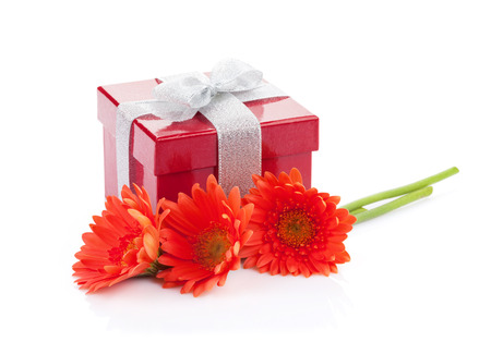 Orange gerbera flowers and red gift box. Isolated on white backgroundの写真素材