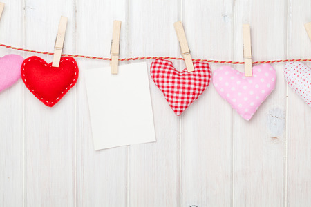 Photo frame and valentines day toy hearts over white wooden backgroundの写真素材