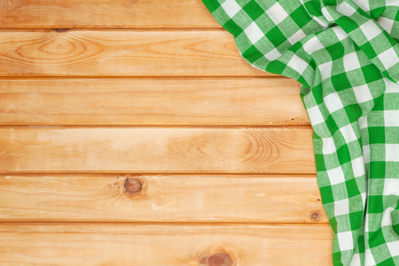 Green towel over wooden kitchen table. View from above with copy spaceの写真素材