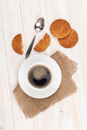 Coffee cup, gingerbread cookies and spoon. On white wooden tableの写真素材