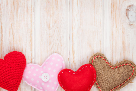 Valentines day background with toy hearts over white wooden tableの写真素材