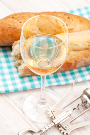 White wine and bread on white wooden tableの写真素材