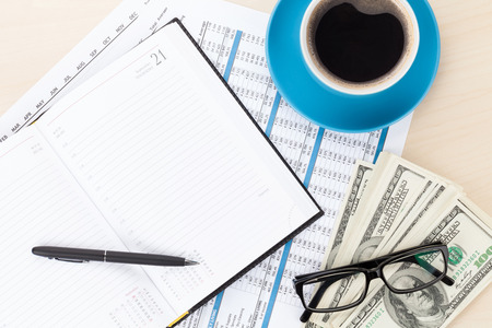 Office desk with reports, blank notepad and money cash. View from above with copy spaceの写真素材