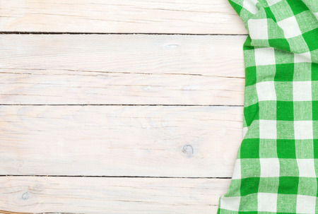 Green towel over wooden kitchen table. View from above with copy spaceの写真素材