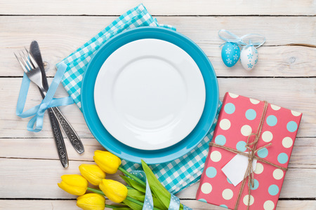 Easter with yellow tulips, colorful eggs and gift box. Top view