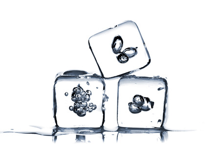 Three melting ice cubes with air bubbles inside on white backgroundの写真素材