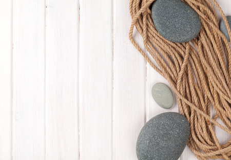 Wooden background with marine rope, sea stones and copy spaceの写真素材
