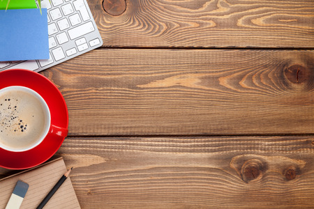 Office desk table with computer, supplies and coffee cup. Top view with copy space