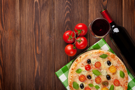 Pizza and red wine on wooden table background. Top view with copy spaceの写真素材