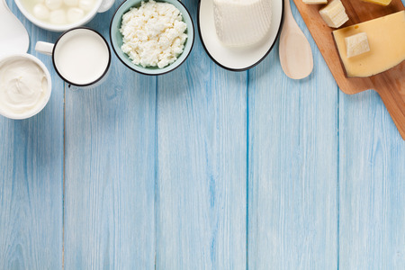 Dairy products on wooden table. Sour cream, milk, cheese, egg, yogurt and butter. Top view with copy spaceの写真素材