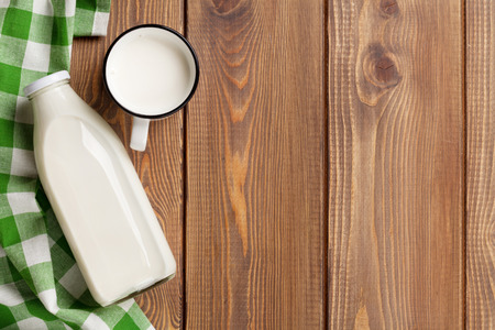 Milk cup and bottle on wooden table. Top view with copy spaceの写真素材