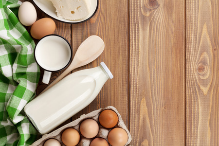 Dairy products on wooden table. Milk, cheese and eggs. Top view with copy spaceの写真素材