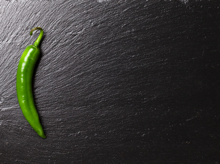 Green chili pepper on black stone table with copy spaceの写真素材
