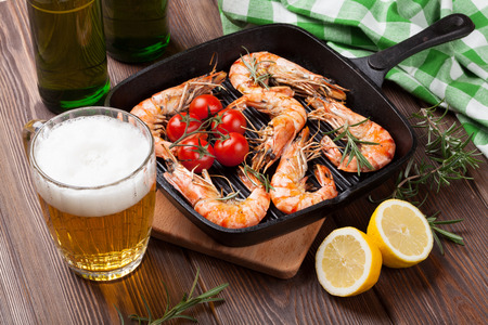 Grilled shrimps on frying pan and beerの写真素材