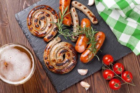 Beer mug and grilled sausages on wooden table. Top viewの写真素材