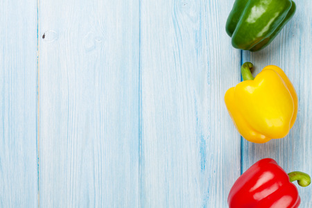 Colorful bell peppers on wooden table. Top view with copy spaceの写真素材