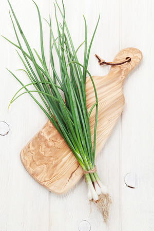 Fresh garden spring onion on cutting board. Top viewの写真素材