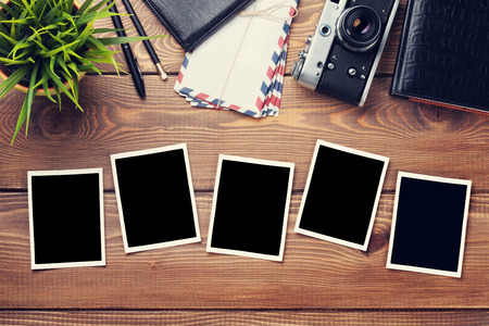 Blank photo frames, camera and supplies on wooden table. Top view. Tonedの写真素材