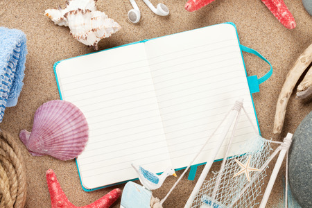 Travel and vacation notepad with items over sea sand. Top view with copy spaceの写真素材