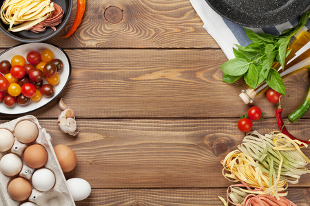 Pasta cooking ingredients and utensils on wooden table. Top view with copy spaceの写真素材