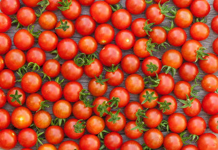 Ripe cherry tomatoes texture on wooden tableの写真素材