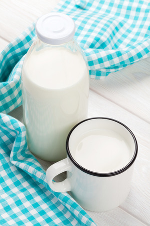 Milk cup and bottle on wooden tableの写真素材