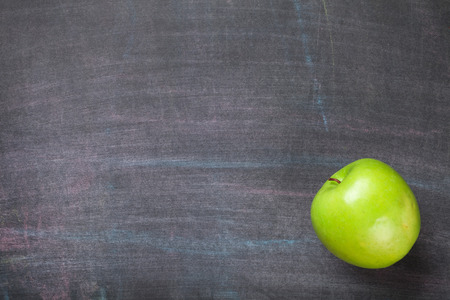 Green apple on blackboard or chalkboard background. Top view with copy spaceの写真素材