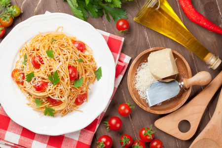 Spaghetti pasta with tomatoes and parsley on wooden table. Top viewの写真素材