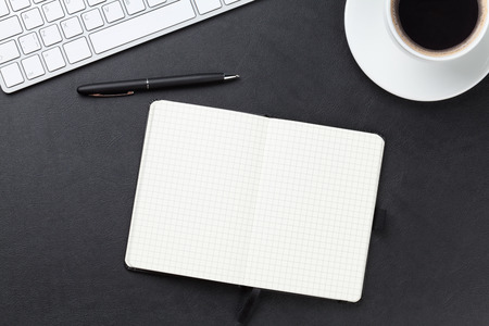 Office leather desk table with computer, supplies and coffee cup. の写真素材