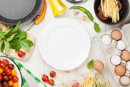 Pasta cooking ingredients and utensils on wooden table. の写真素材