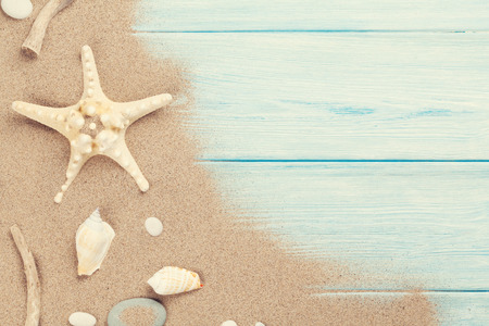 Sea sand with starfish and shells on wooden table. の写真素材