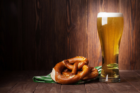 Lager beer glass and pretzel on wooden table. View with copy spaceの写真素材