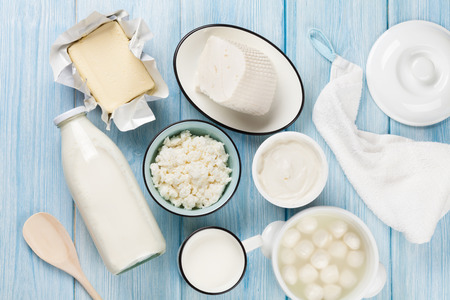 Dairy products on wooden table. Sour cream, milk, cheese, egg, yogurt and butter. Top viewの写真素材